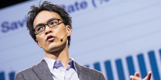 Homme en veste grise faisant une présentation avec un graphique en arrière-plan montrant le taux d'épargne.