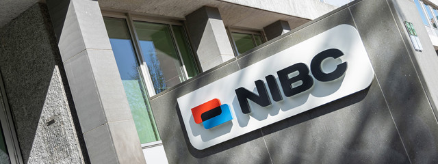 Logo de NIBC sur la façade du bâtiment de bureaux, avec des éléments bleus et rouges saisissants.