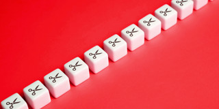 Reeks witte blokken met schaarpictogrammen op een felrode achtergrond.